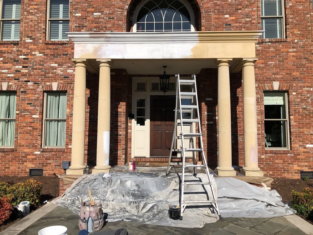 Painters repainting the exterior of a brick home in Middle Tennessee